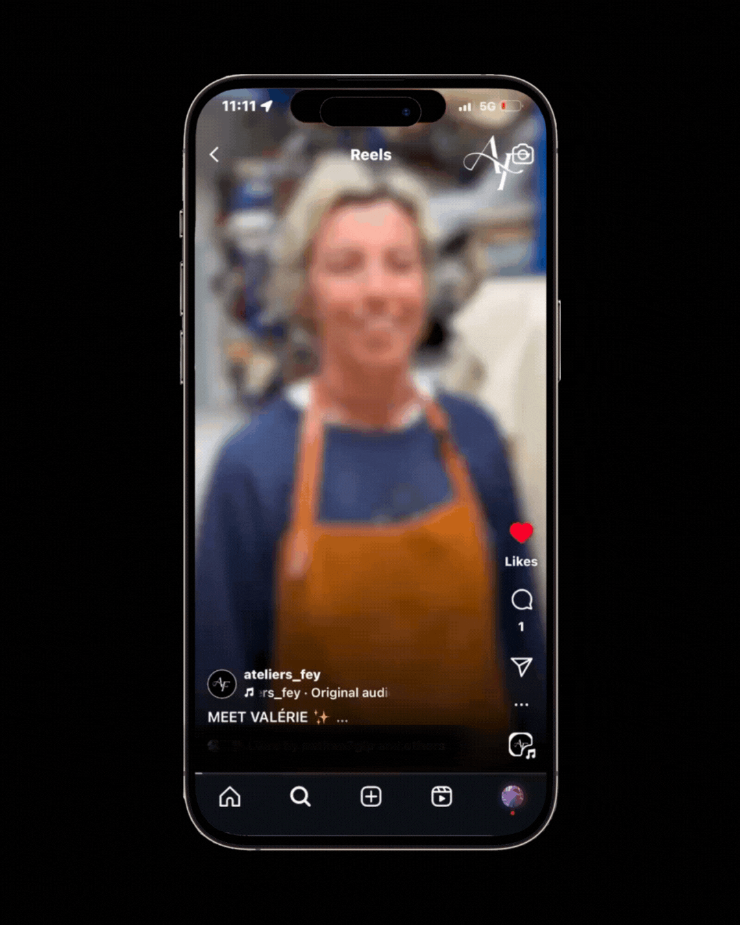 Capture d'écran d'un téléphone affichant une vidéo TikTok floue d'une femme nommée Valérie, portant un tablier orange, dans un environnement probablement artisanal ou de travail.