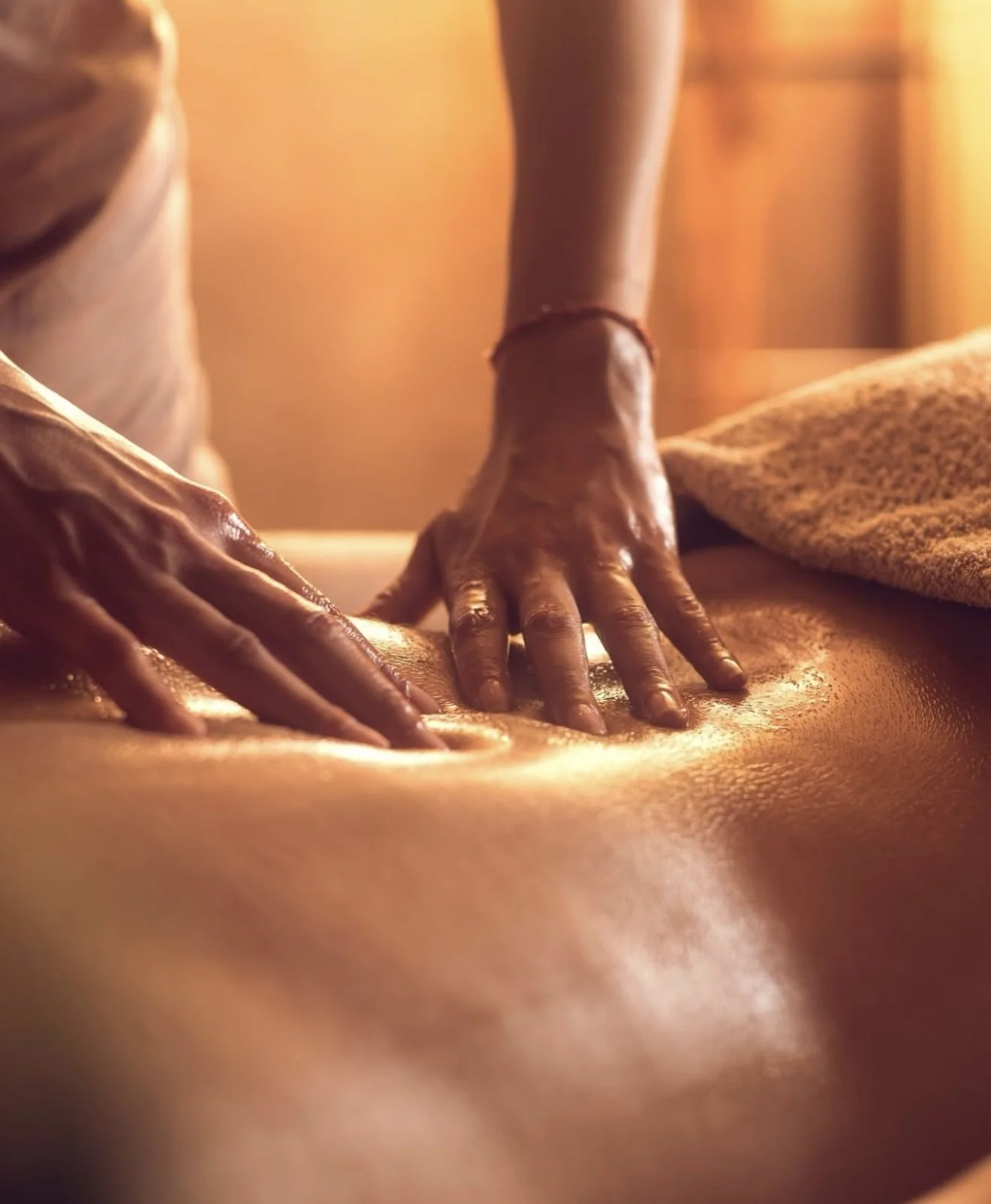 Une personne donne un massage sur le dos d'une autre personne dans une ambiance chaleureuse.