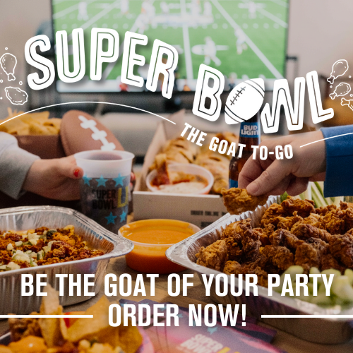 Table with various party foods including fried chicken, nachos, and dips, with people reaching for the food, and football-themed decorations in the background.