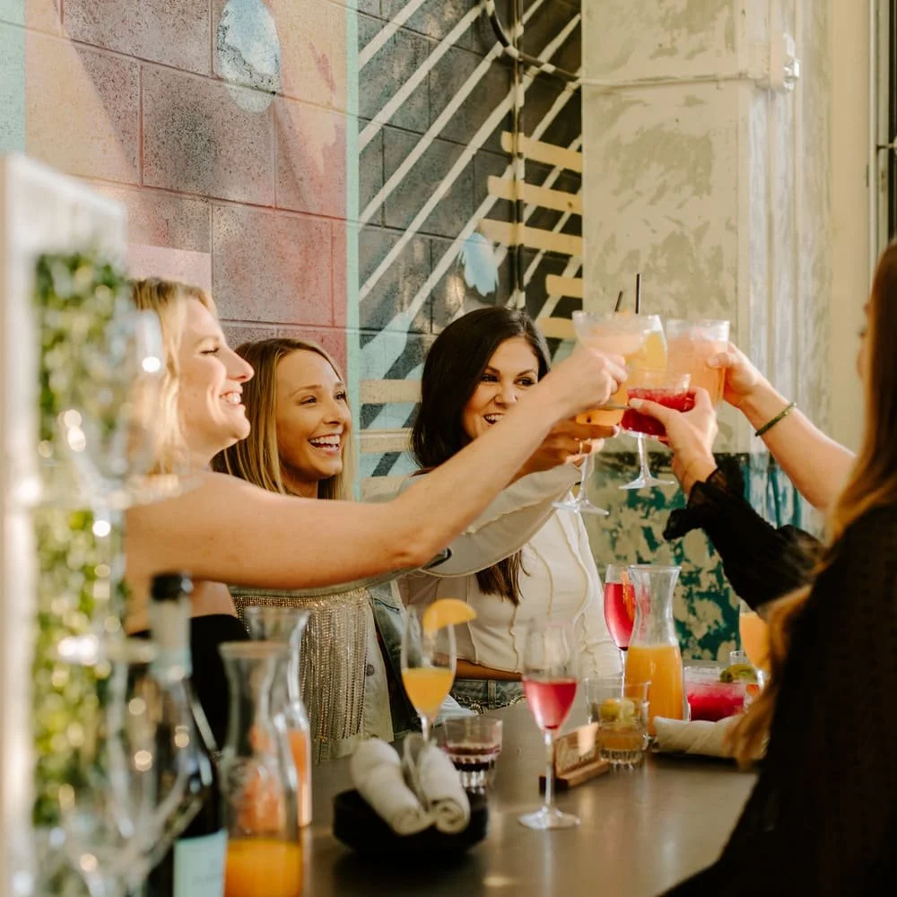Group of women celebrating with cocktails in a bar or restaurant.