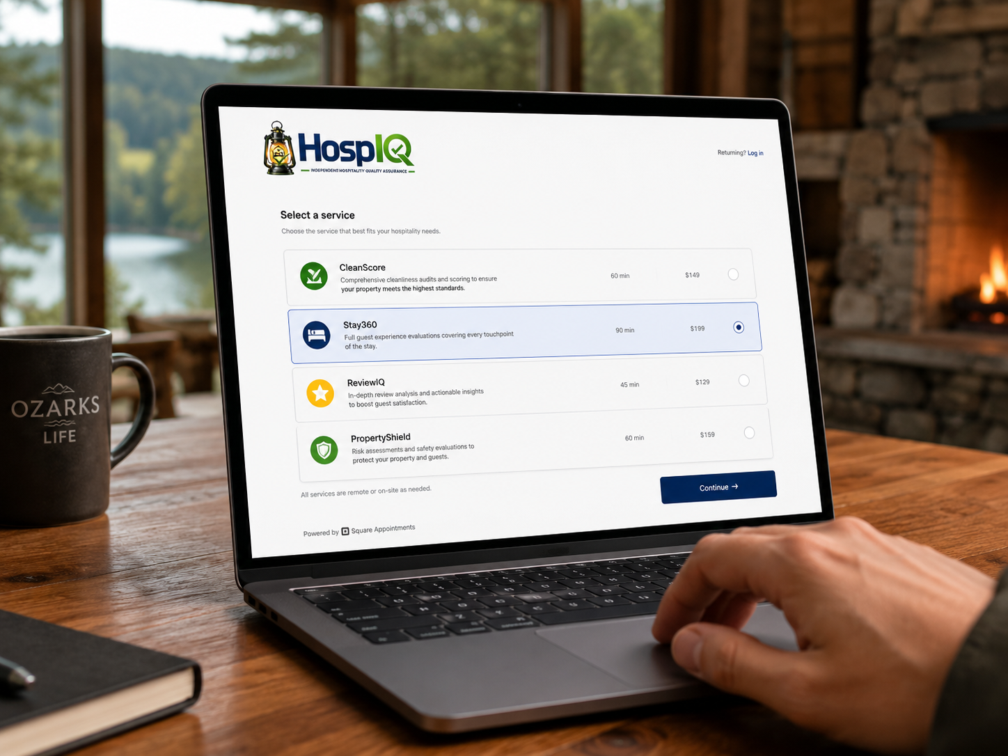 Laptop displaying a booking service interface for hospitality quality assurance, with options like CleanScore, Stay360, ReviewIQ, and PropertyShield, on a wooden table in a cozy room with a coffee mug and a notebook nearby.