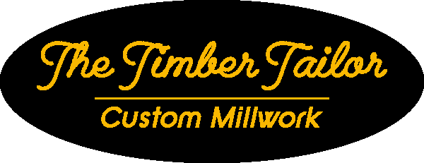 The Timber Tailor logo with yellow text on a black oval background, reading 'The Timber Tailor' and 'Custom Millwork'.