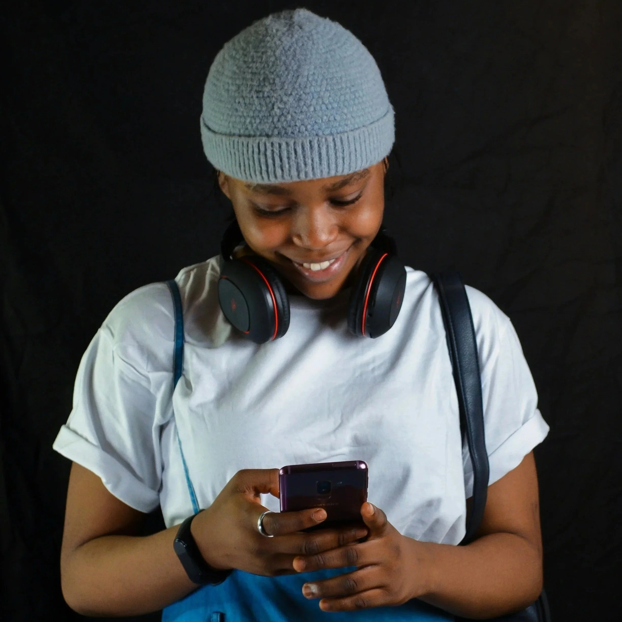 Neurodivergent, Autistic, or ADHD'er wearing sensory headphones looking at their phone