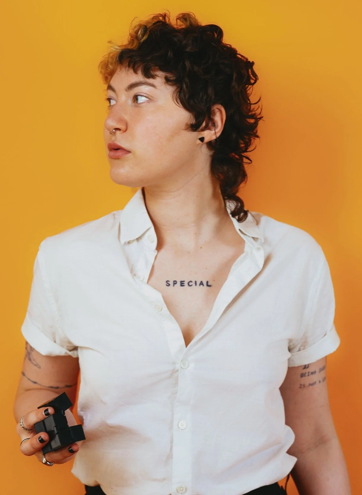 White Non-Binary Person with Stim Toy.jpg