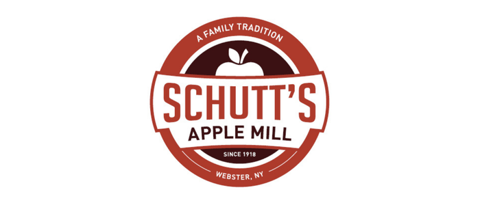 Logo for Schutt's Apple Mill, featuring a red circle with a white apple and text indicating a family tradition since 1918 in Webster, NY.
