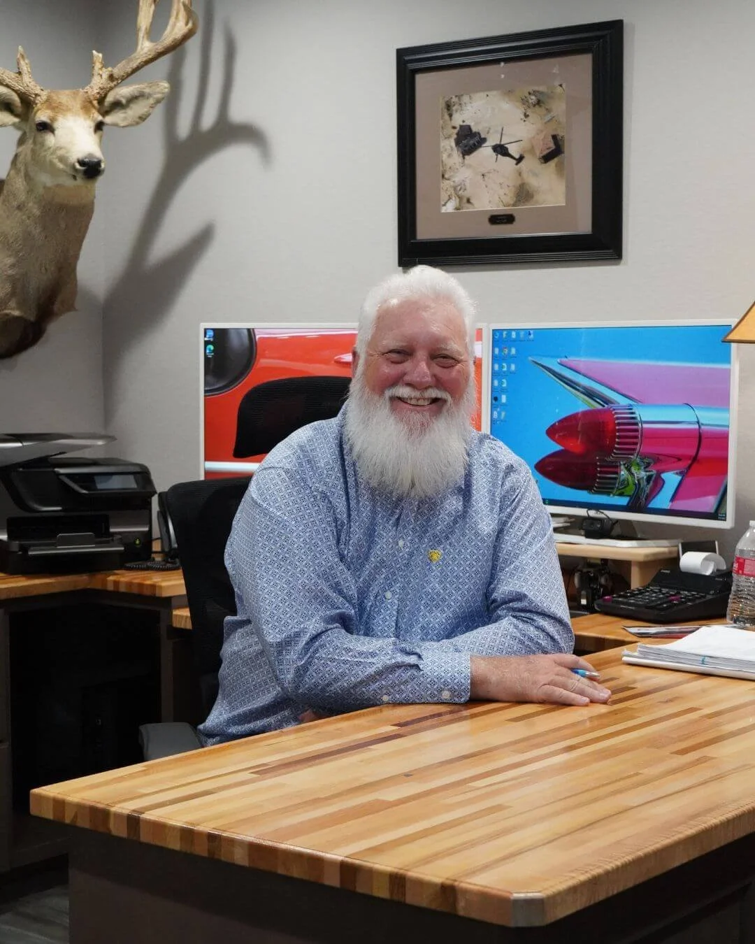 Hard Working Business Man (and founder) of Gems Custom Homes sitting at his office desk smiling