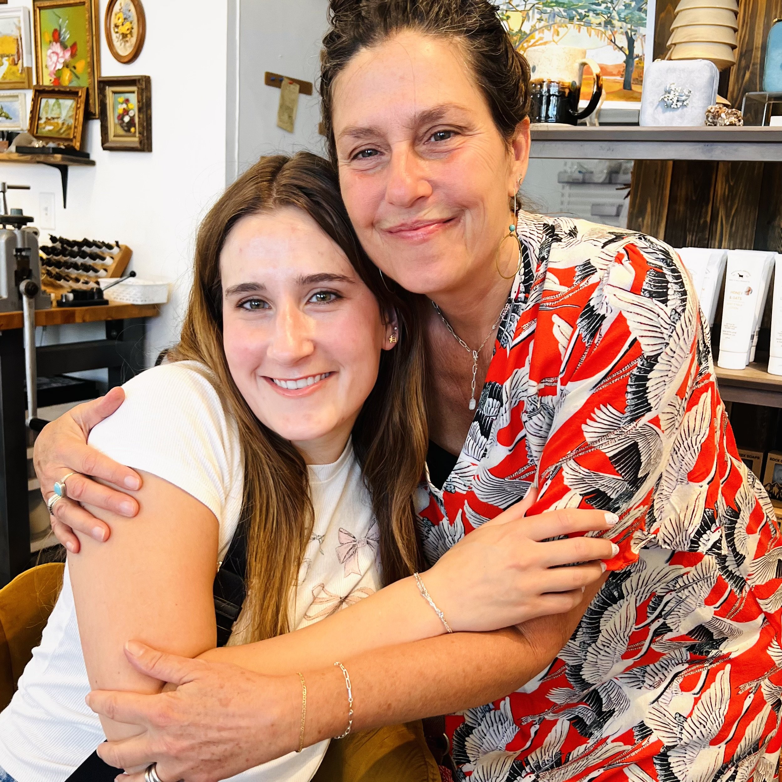 A mother and daughter showing off their new infinite permanent jewelry bracelets