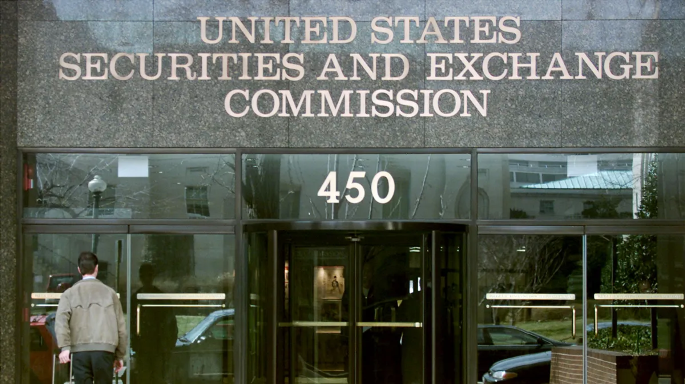 Entrance of the United States Securities and Exchange Commission building with the address 450 displayed above the glass doors.