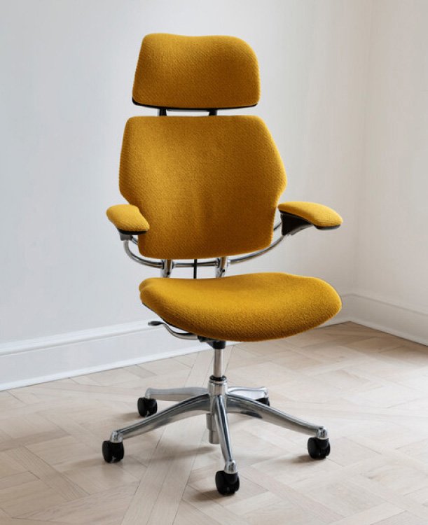 Yellow office ergonomic chair with adjustable armrests and high backrest, on casters, in a minimal room.