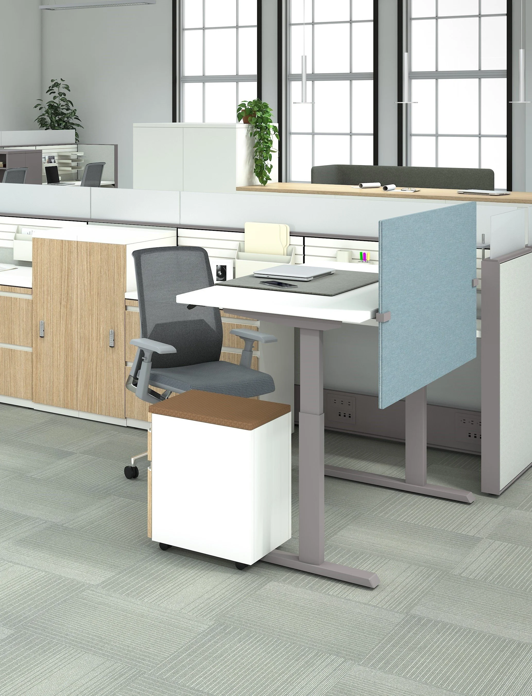 Modern office workspace with a desk, swivel chair, small roll-top storage, and a cubicle wall partition, with large windows in the background.