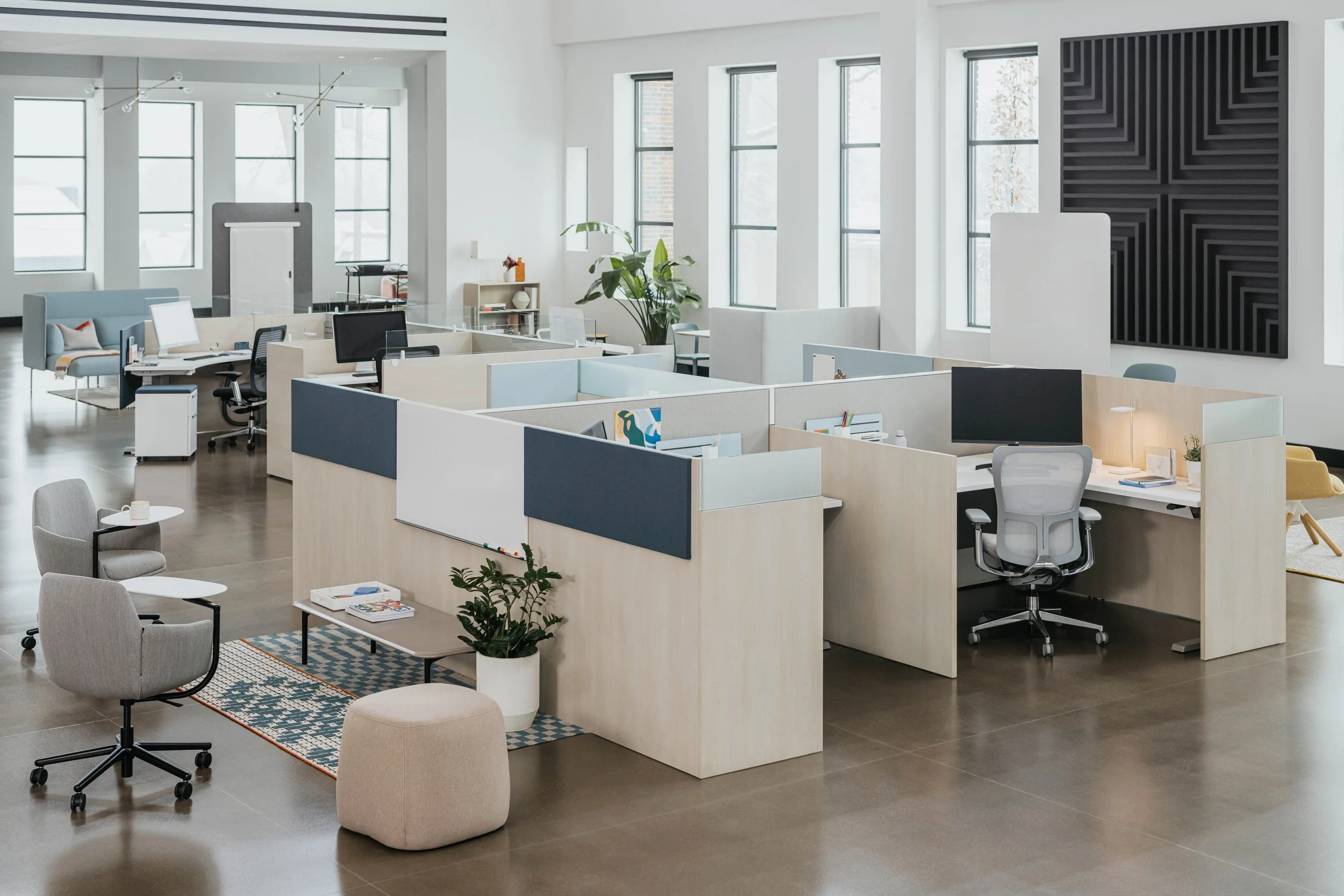 Modern open-plan office with individual cubicles, desks, chairs, and decor, large windows, and minimalist furniture.