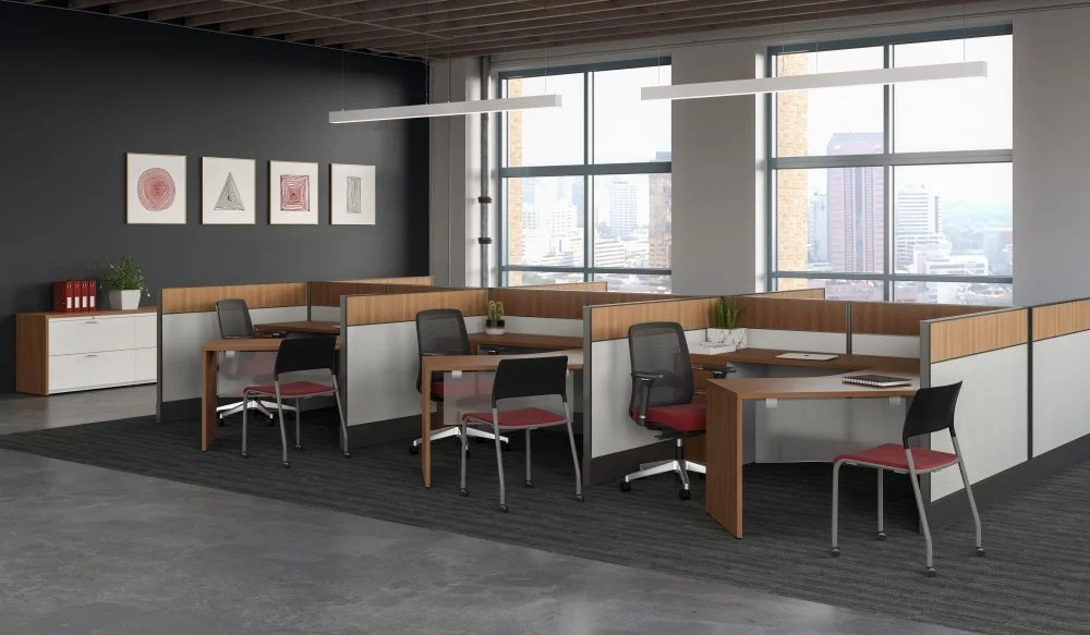 Modern office space with four work stations, black and red chairs, large windows showing city buildings, and wall art with geometric patterns.