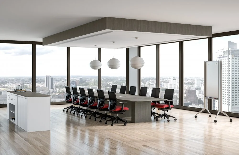 Modern conference room with large windows, a long table with black and red chairs, a whiteboard on rolling stand, and city skyline view