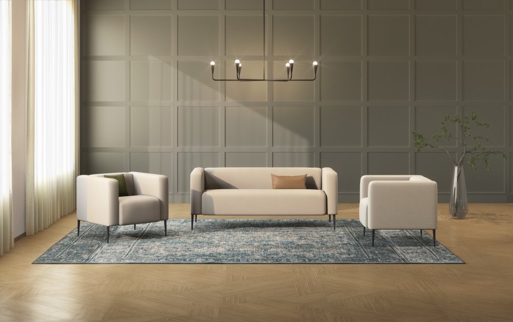 Modern living room with a gray paneled wall, a black chandelier, white sofa and chairs with pillows, a blue patterned area rug, and a tall plant in a vase.