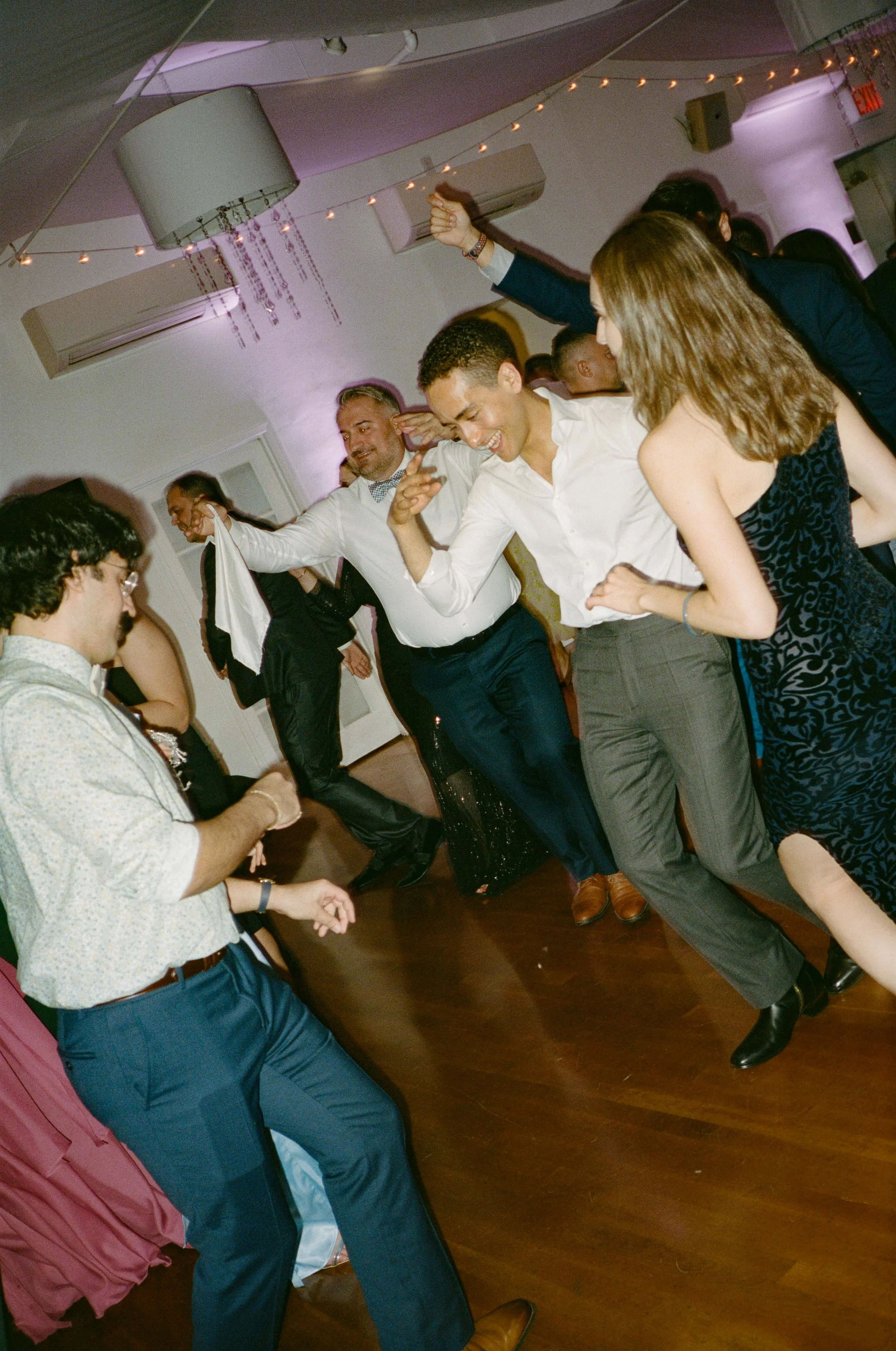 People dancing and enjoying themselves at a lively party or celebration in a decorated indoor venue.