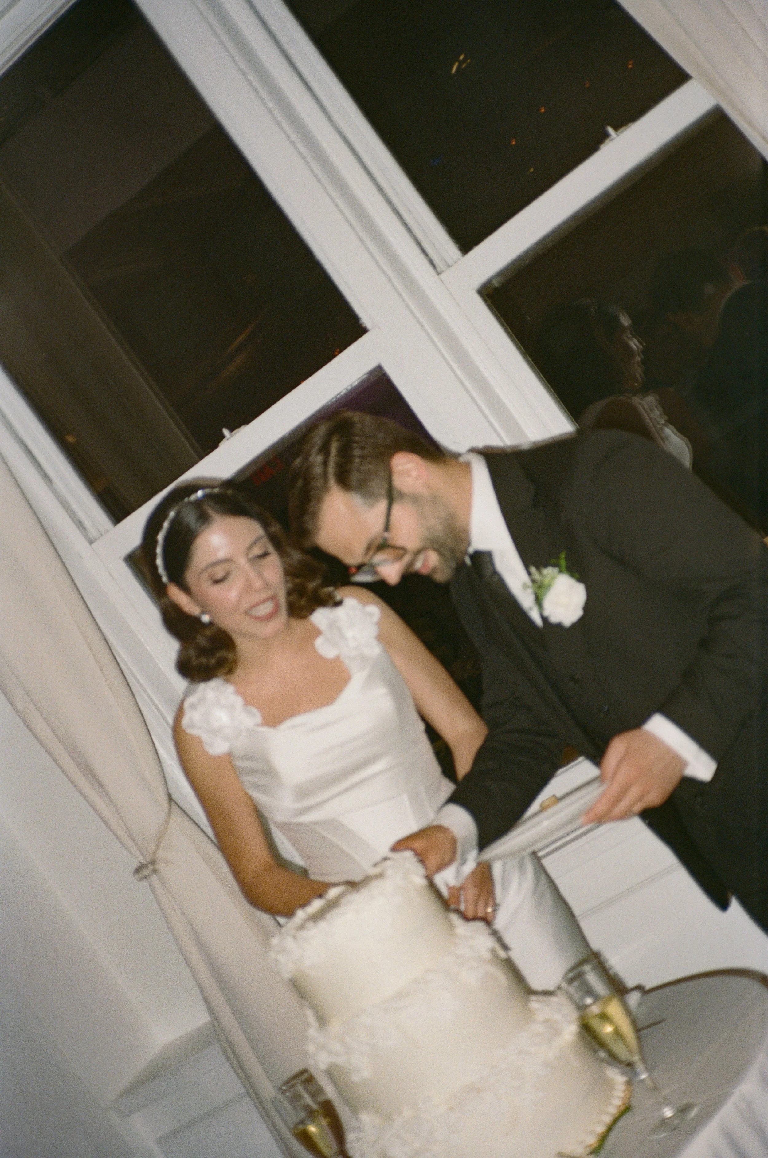 Bride and groom cutting a wedding cake at their reception.