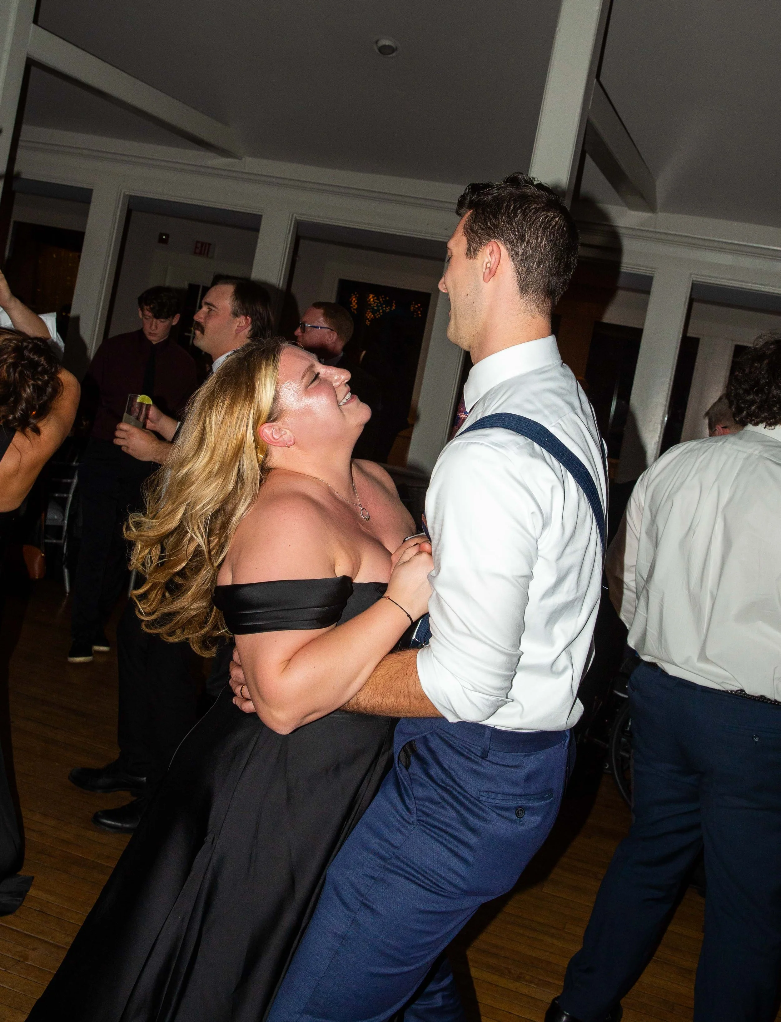 A woman and a man dancing closely and smiling at each other at a party or celebration.