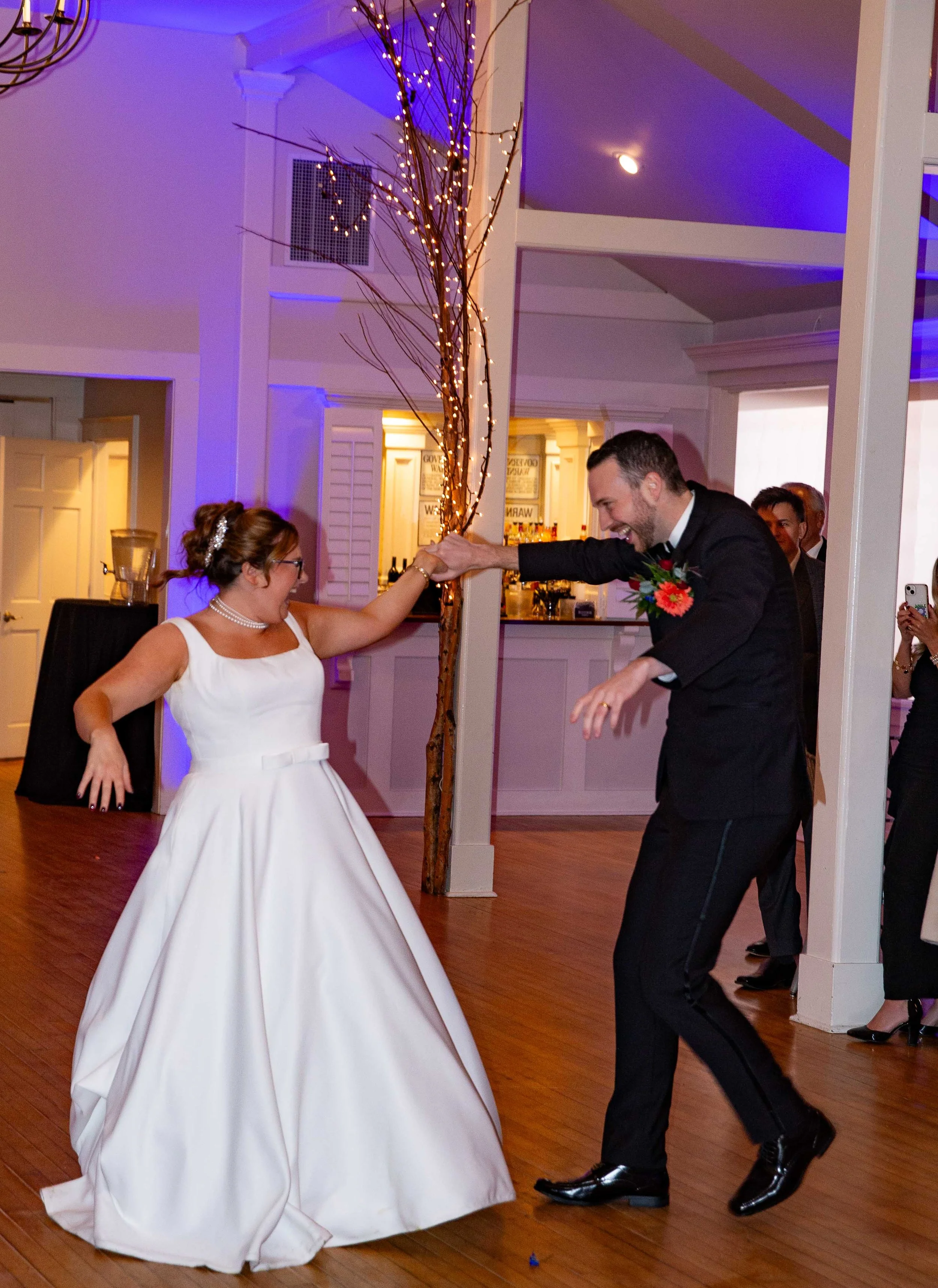 A bride and groom dancing and having fun at their wedding reception.