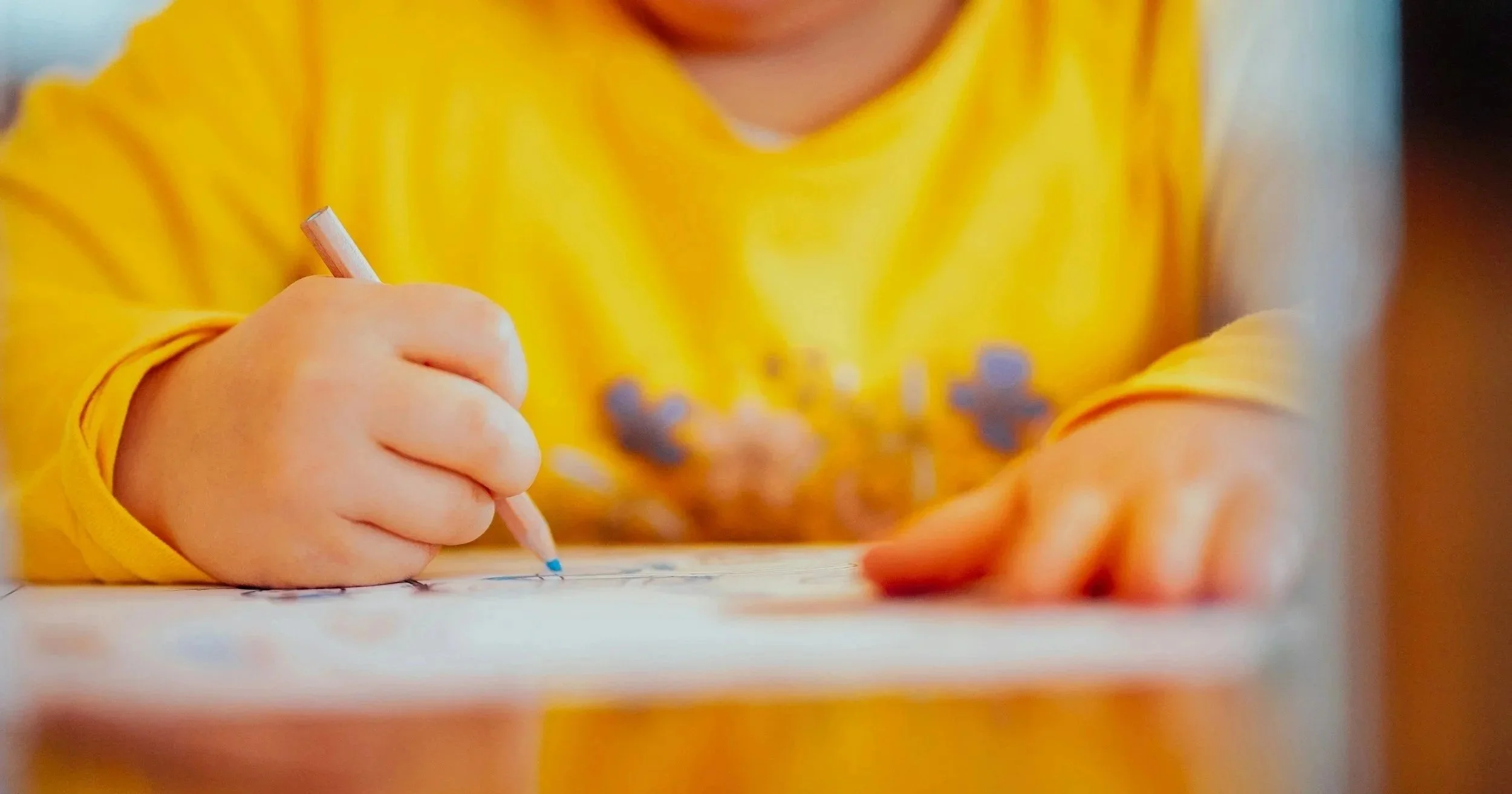 Young child practicing handwriting with a pencil, building early writing skills through hands-on learning — Rooted in Writing subscription box for ages 3–6.