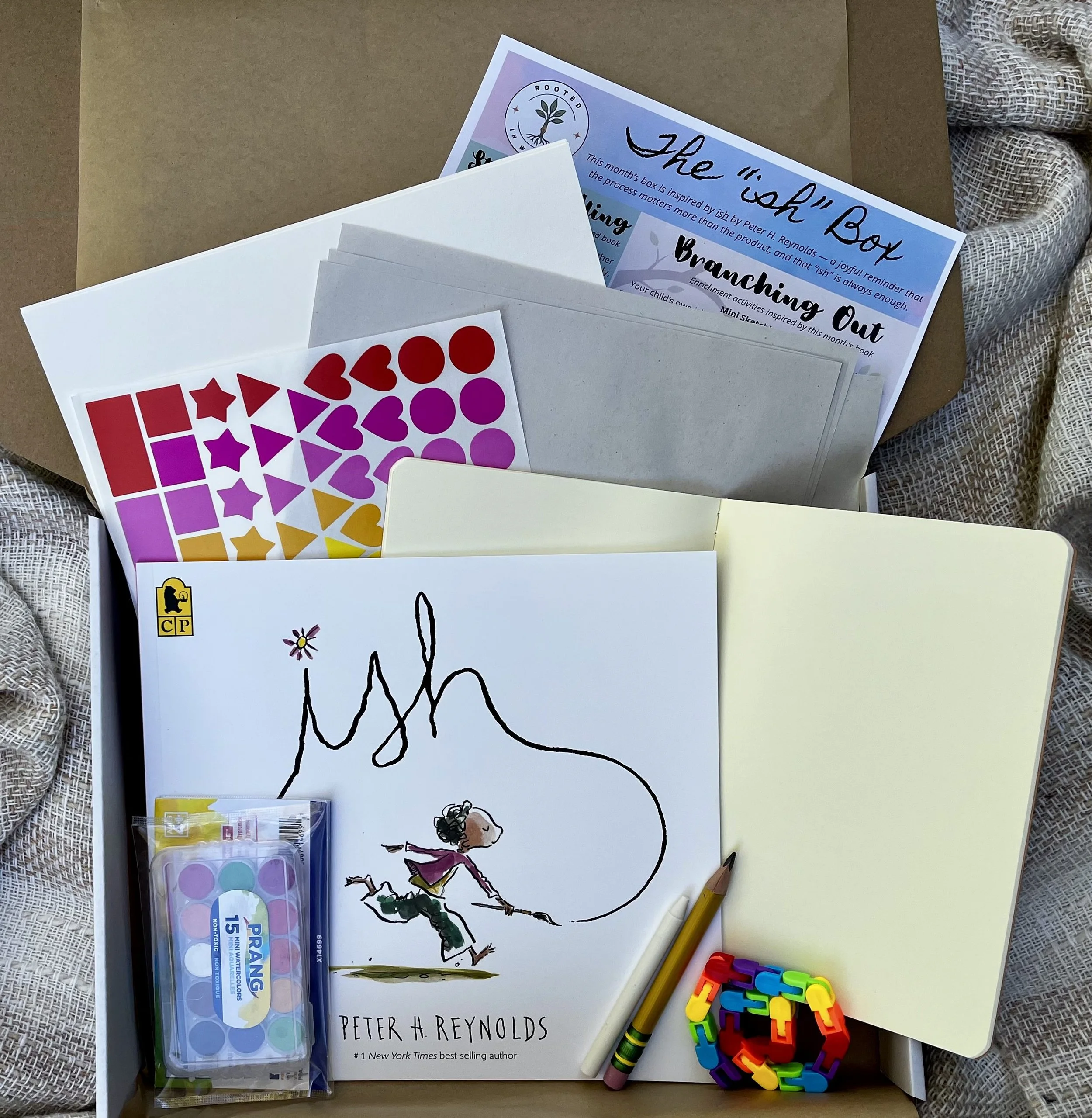Rooted in Writing monthly subscription box contents including the picture book Ish by Peter H. Reynolds, activity sheets, and hands-on fine motor materials for preschoolers.