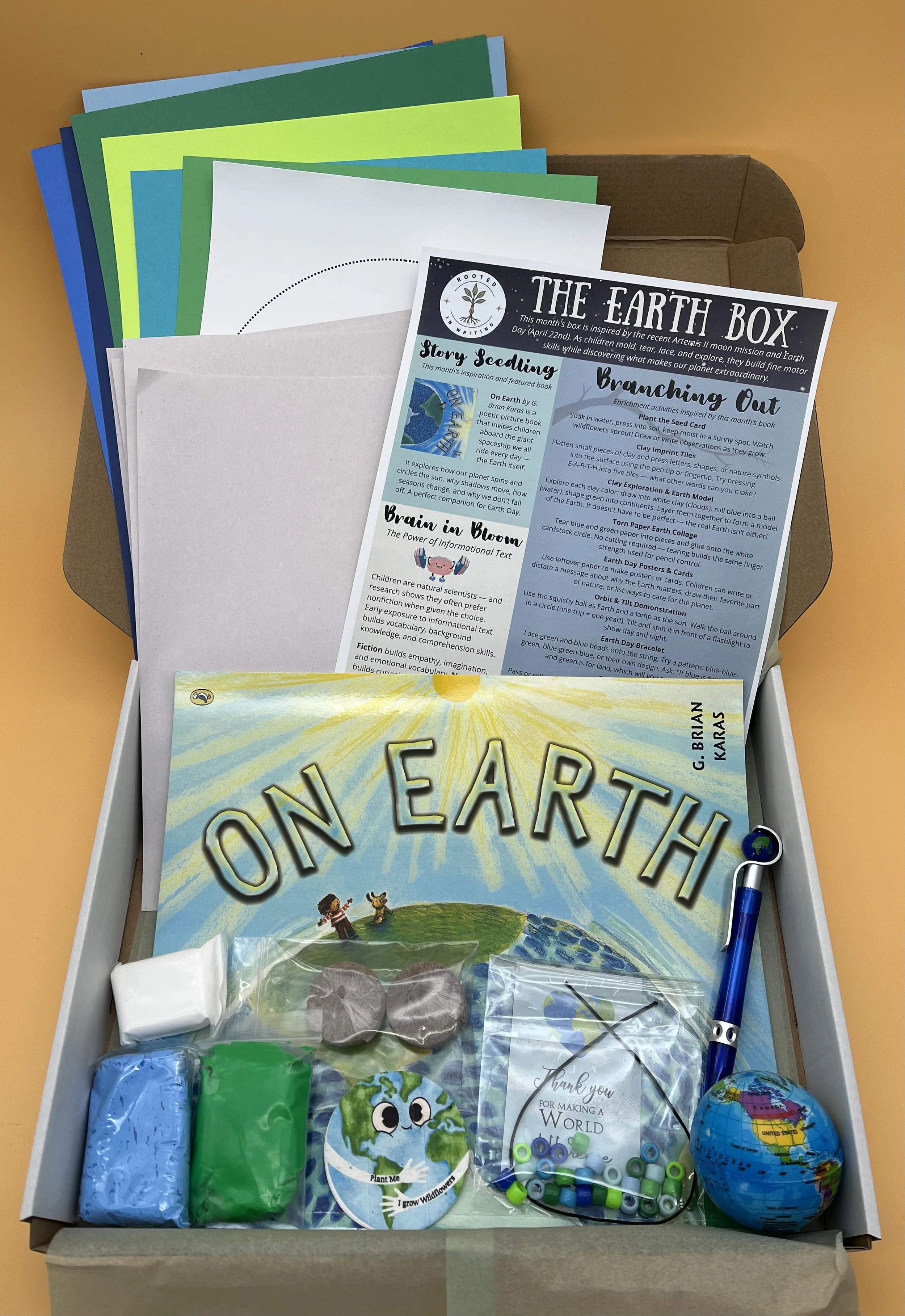 Rooted in Writing Earth Box open and unpacked, featuring the picture book On Earth by G. Brian Karas alongside hands-on early literacy activity materials for preschoolers.