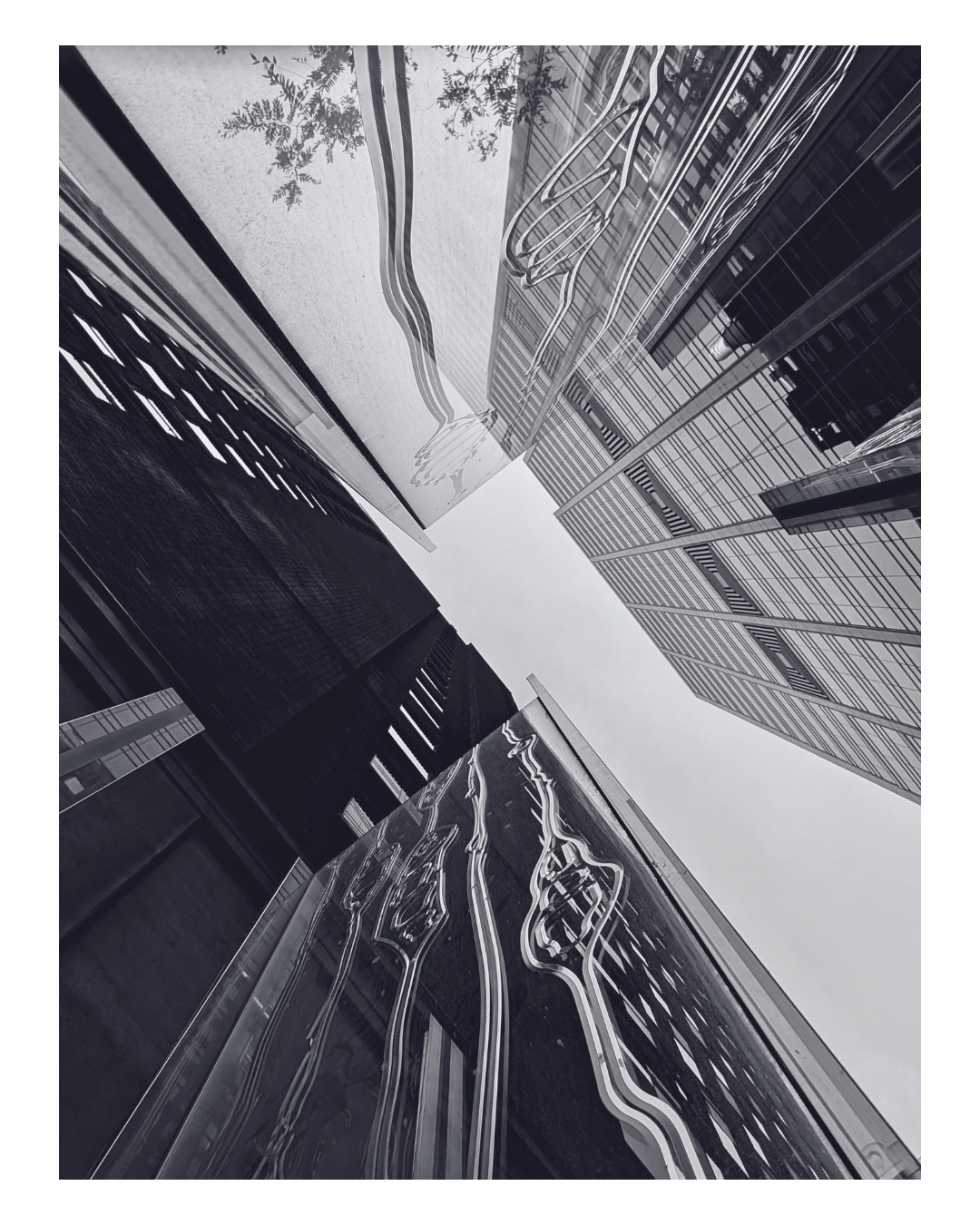 Black and white photo of modern skyscrapers with reflective glass surfaces and a building with LED light design panels.