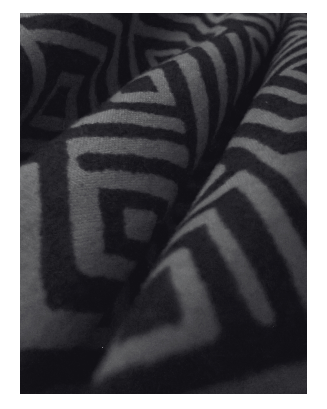 Close-up of black and gray striped fabric with a geometric pattern.