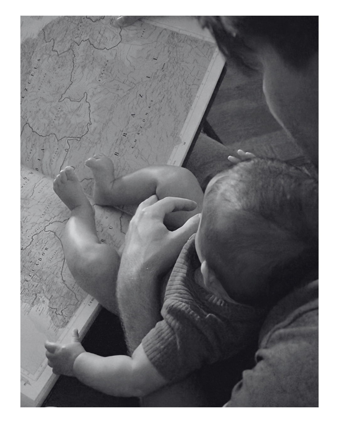 A man holding a baby while looking at a map.