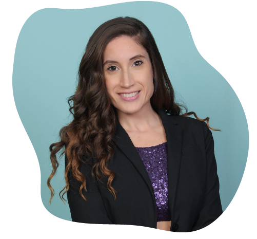 Portrait of a young woman with long, wavy brown hair, smiling, wearing a black blazer over a purple top with sequins, against a teal background to represent her playful company Groov.