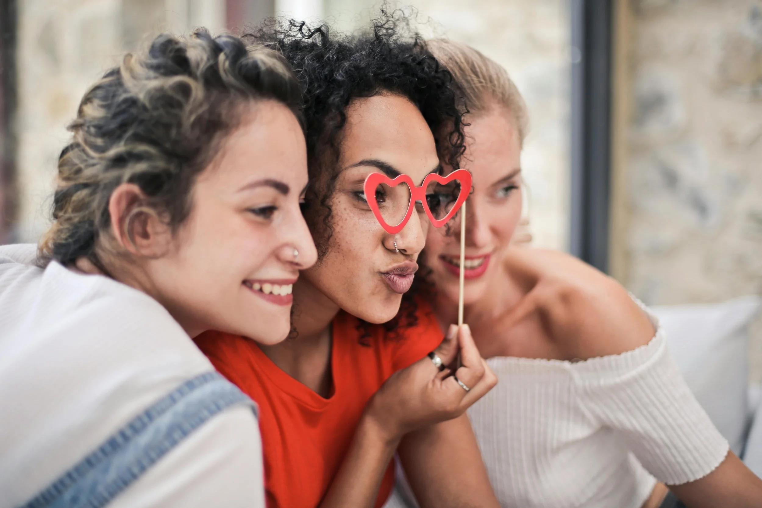 three young women are posing for a photo at a fun and meaningful girls night gathering