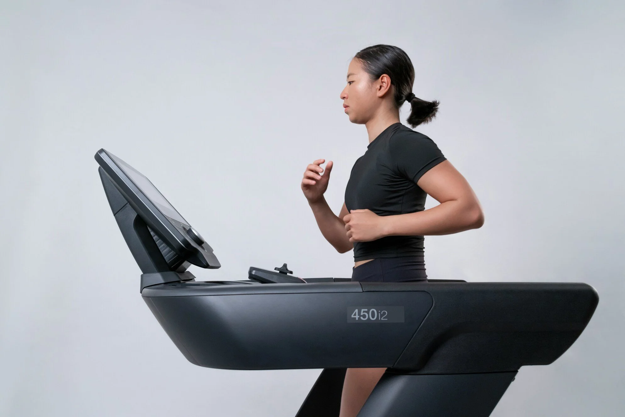 Woman running on a treadmill, highlighting Zone 2 cardio, endurance training and low-impact aerobic fitness.