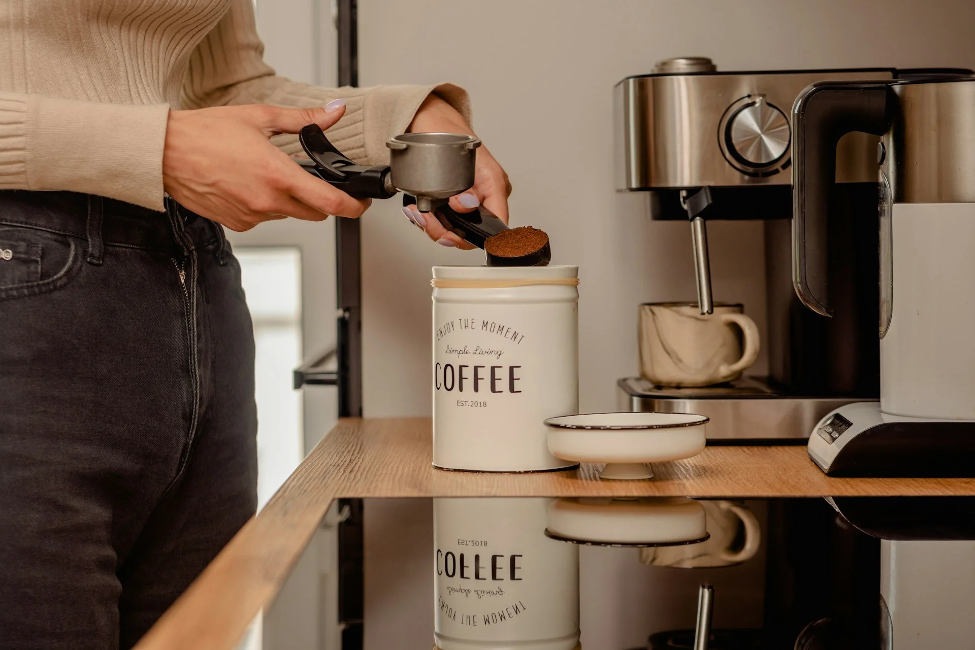 Person preparing coffee with an espresso machine before a workout.
