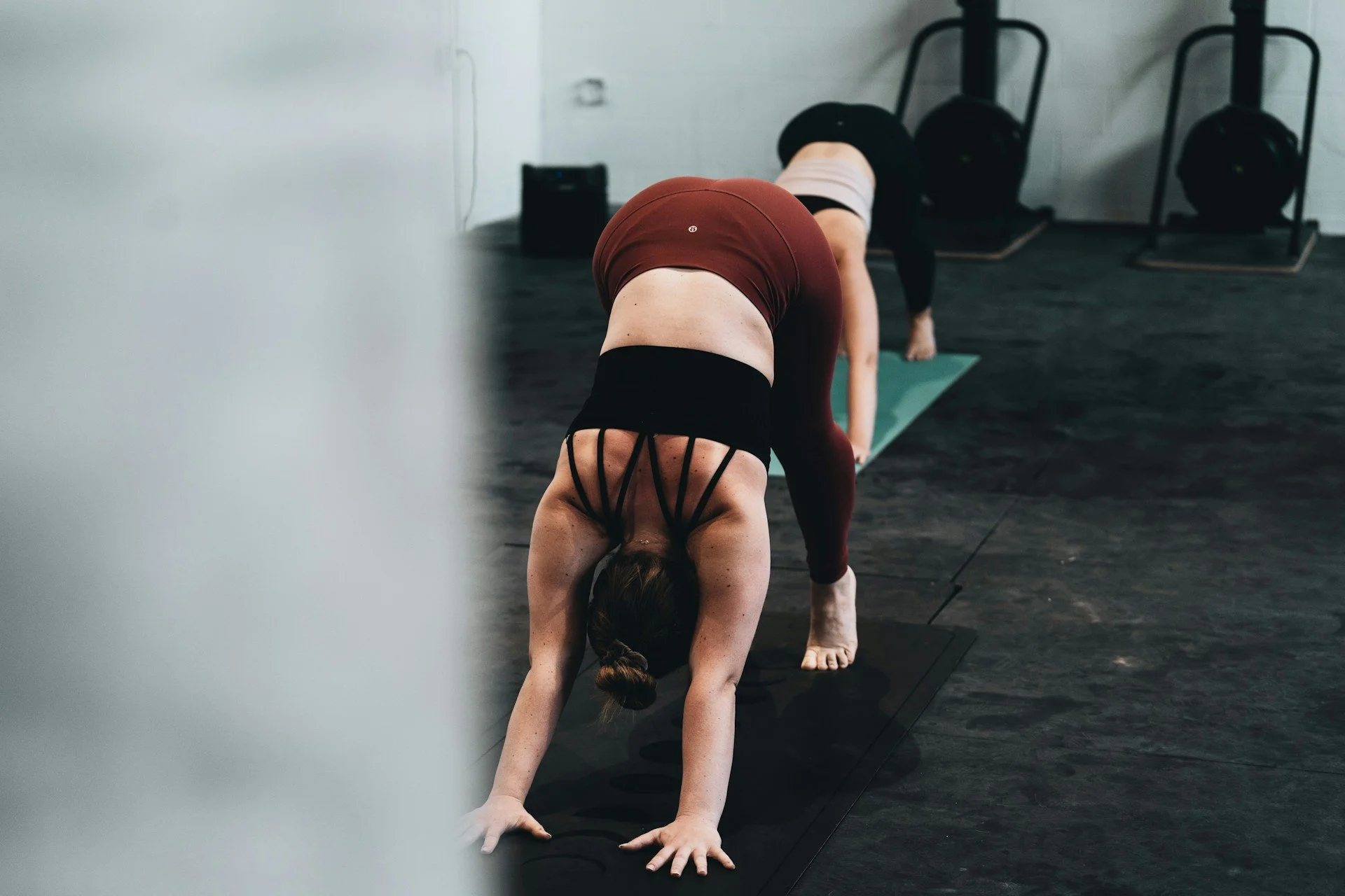 Person stretching in downward dog during a mobility-focused fitness class.