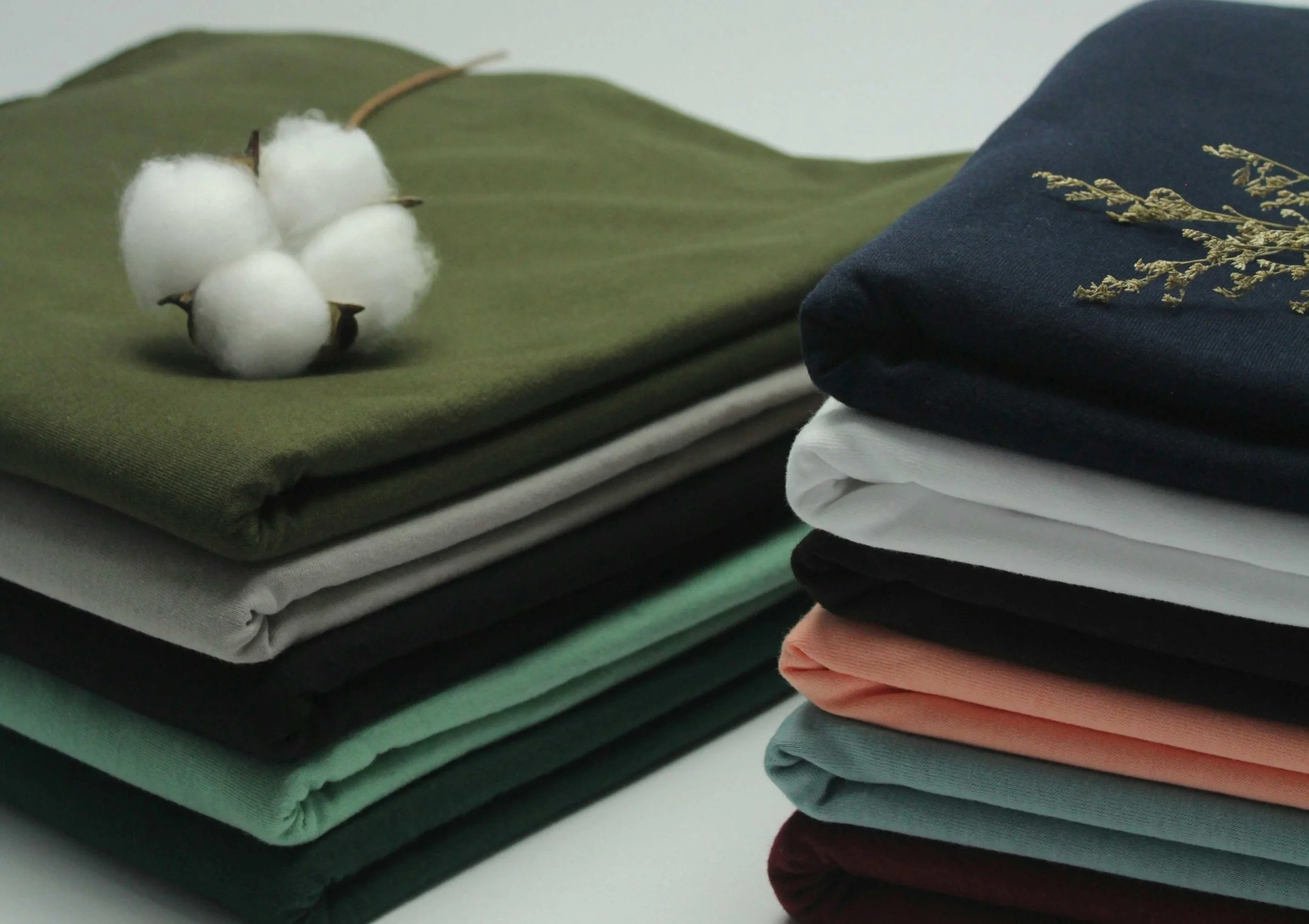 Folded natural fibre activewear and cotton fabric, highlighting sustainable workout clothes and wellness-focused fitness apparel.