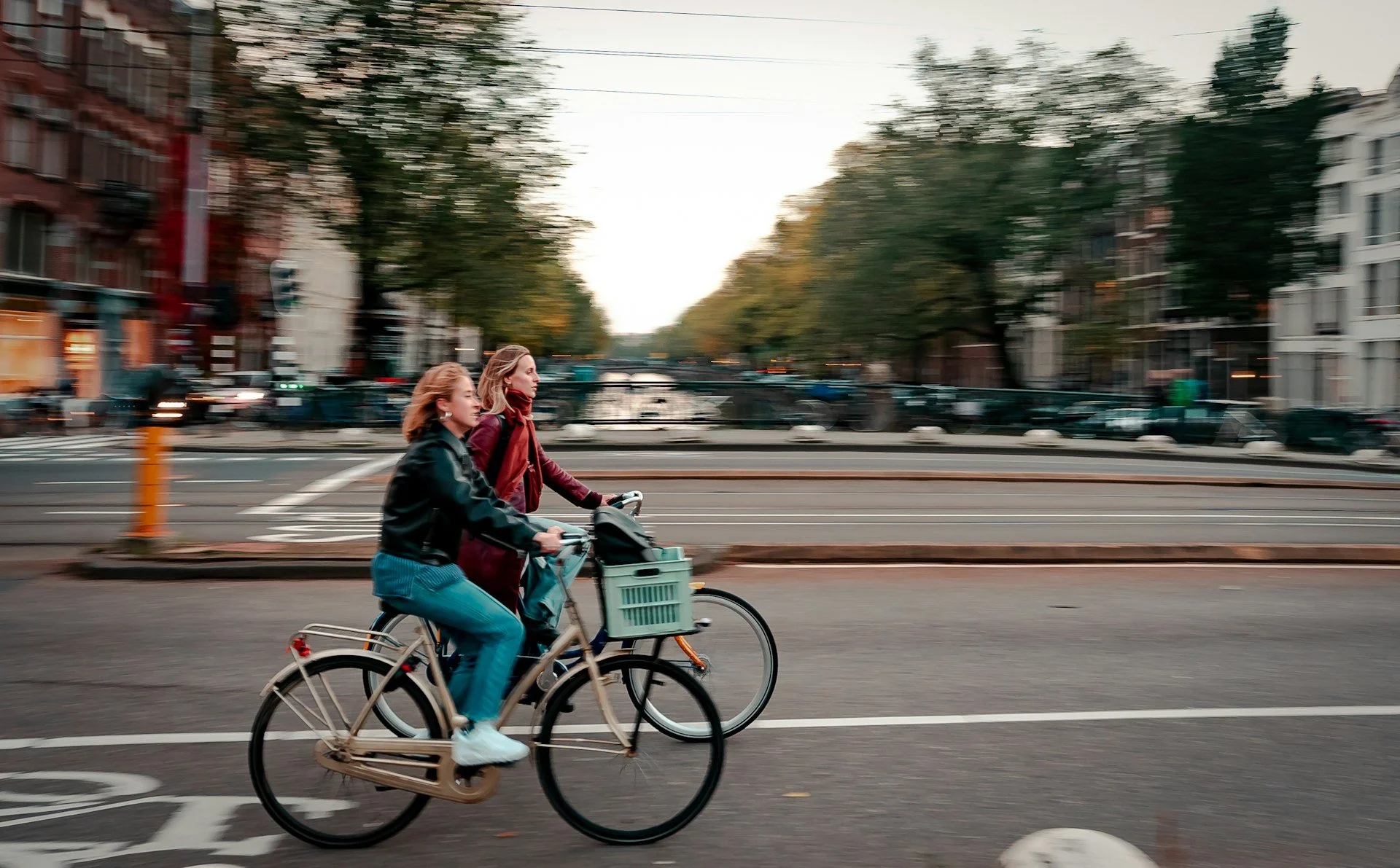 : Two cyclists riding through a city street as everyday active transportation.
