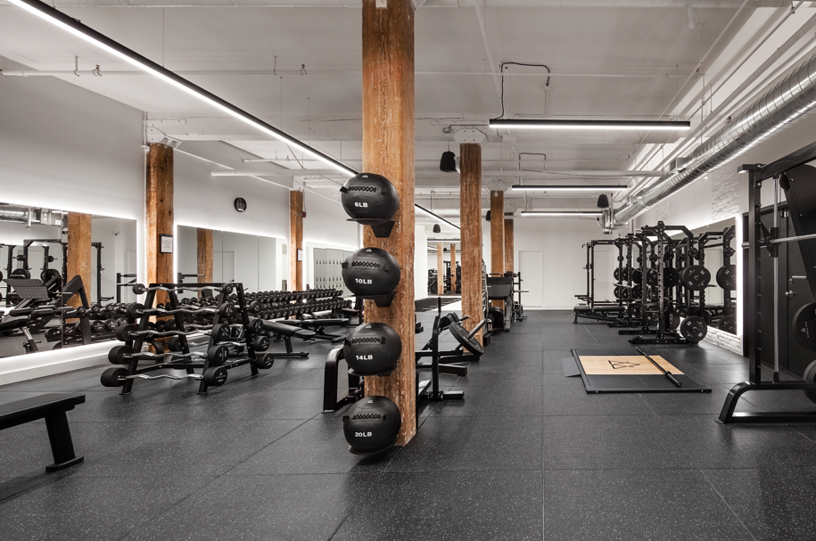 VIMALIFE gym floor with free weights, squat racks and strength training equipment inside a boutique fitness club in Leslieville, Toronto.