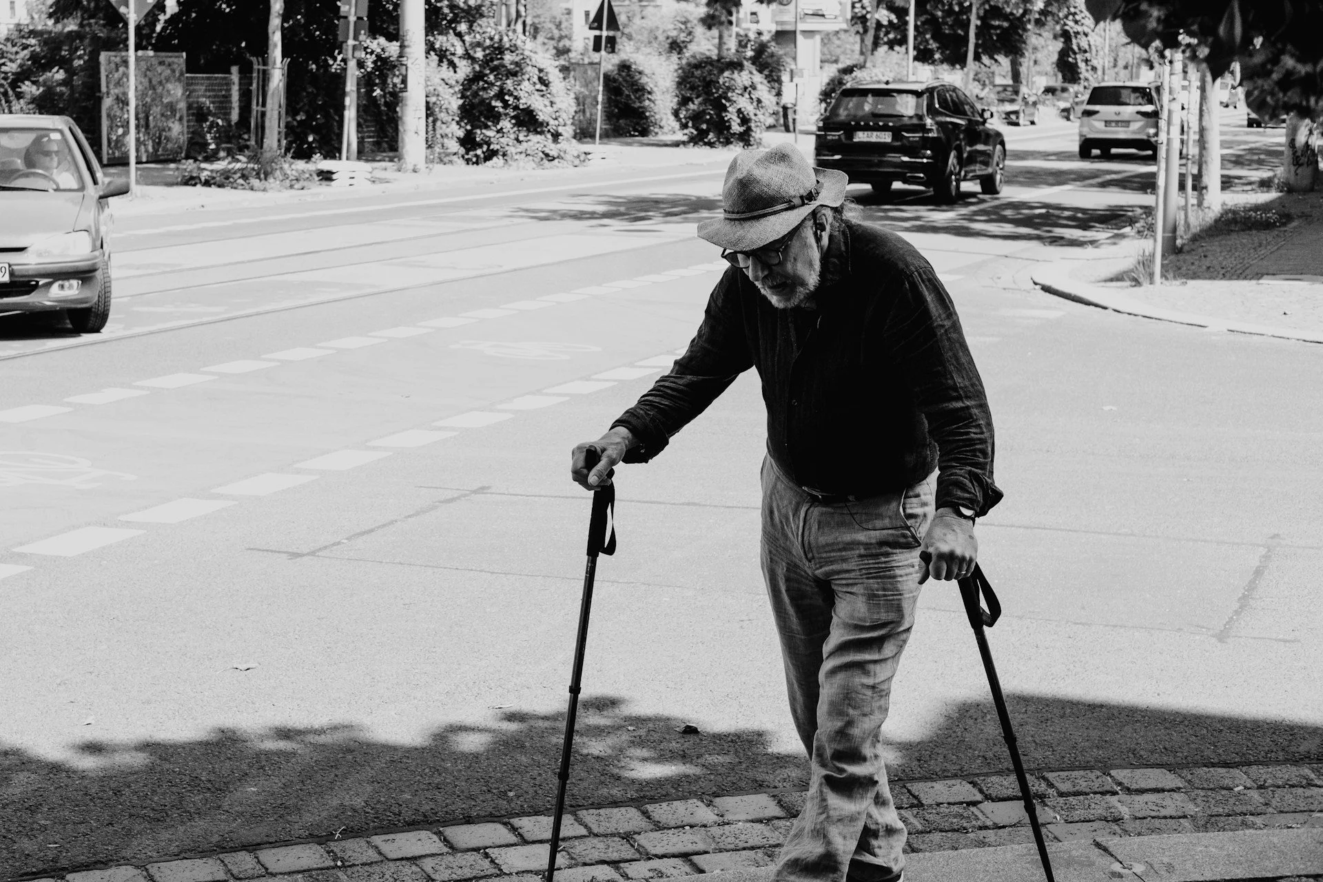 Older adult using walking poles while crossing a city street, highlighting balance and mobilit