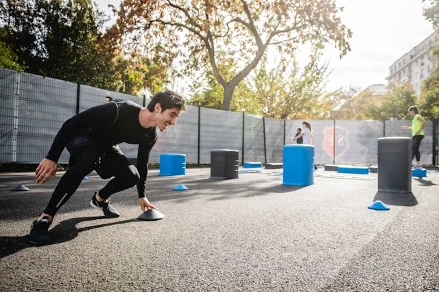 Man completing a cone agility drill during a short outdoor exercise session.