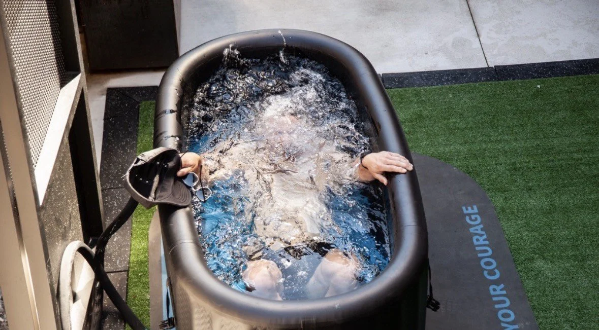 Person using a cold plunge tub for recovery, highlighting contrast therapy, wellness and post-workout recovery