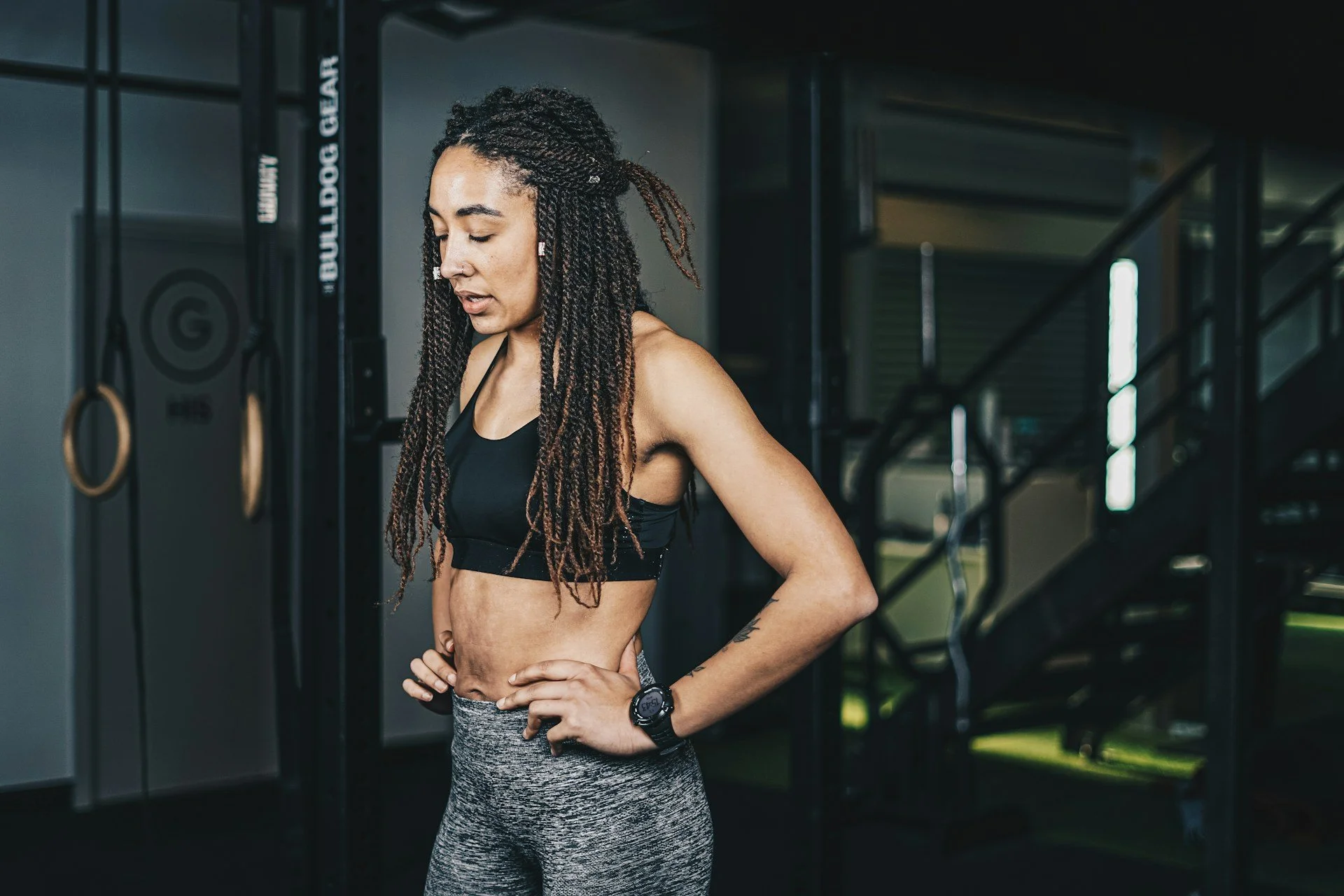 Woman resting in a gym after training, highlighting women’s fitness, recovery, energy and strength performance.