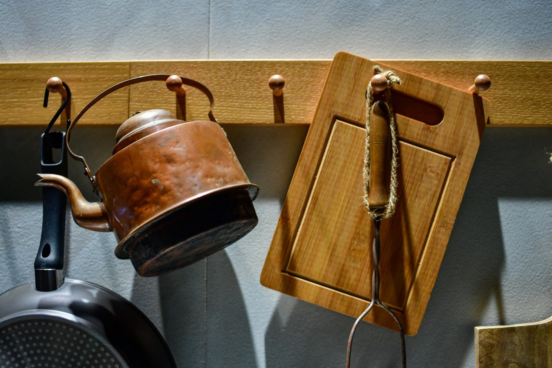 Copper kettle and wooden kitchen tools, highlighting natural materials, low-plastic living and wellness-focused home choices.