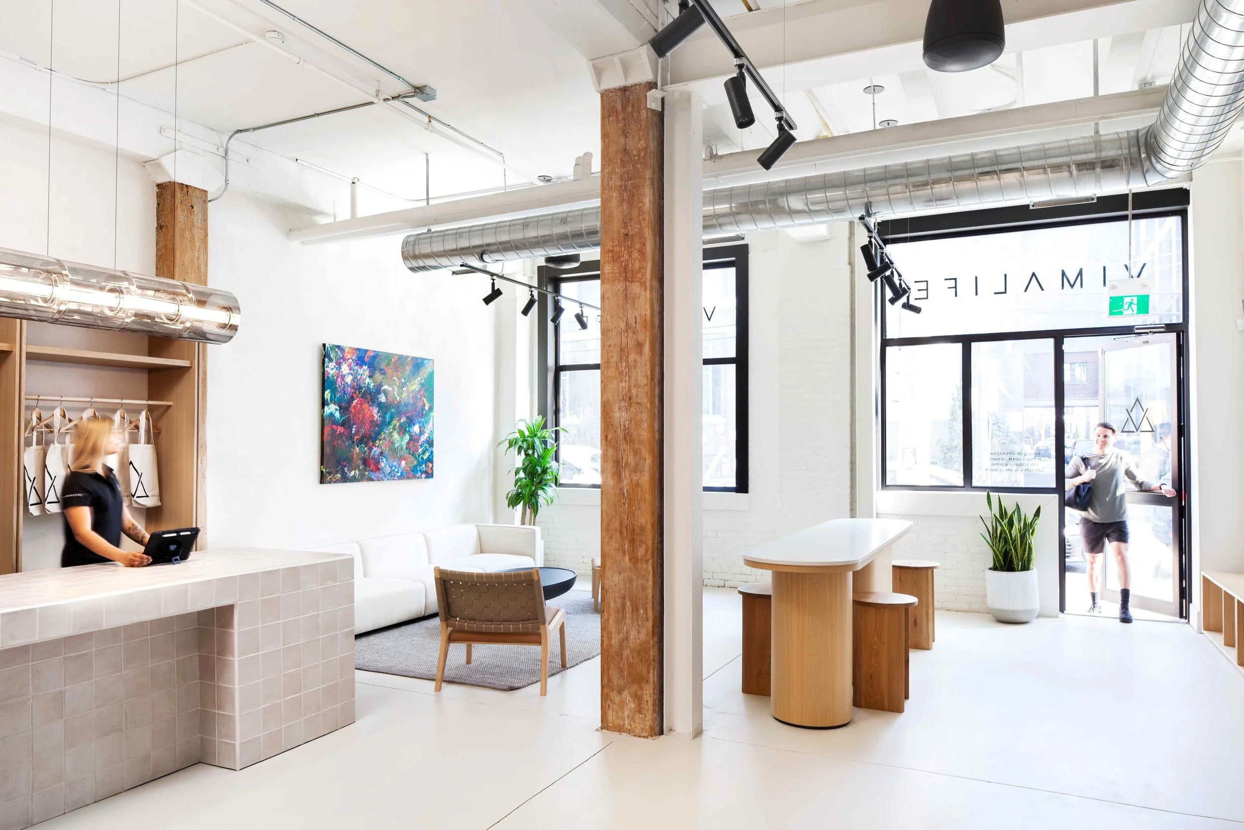 Bright VIMALIFE reception area with modern seating, front desk and gym entrance.