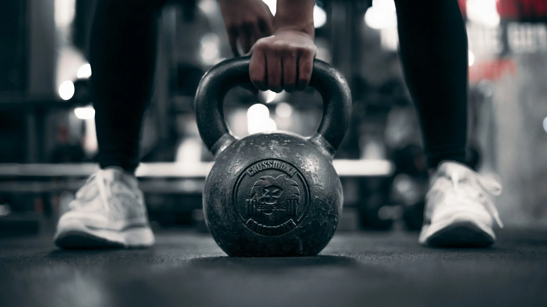Close-up of a person lifting a kettlebell, highlighting strength training, functional fitness and workout performance.