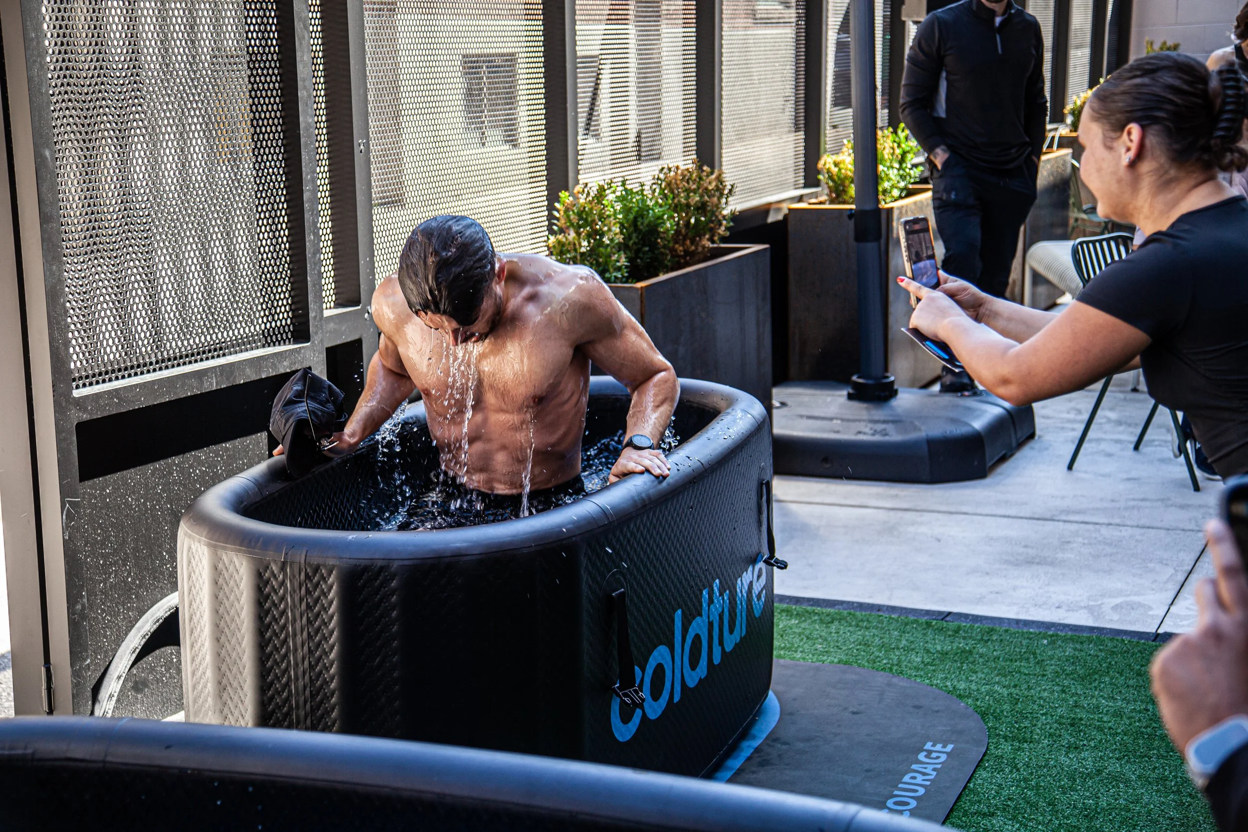 Person using a cold plunge tub, highlighting cold therapy, recovery and wellness after exercise.