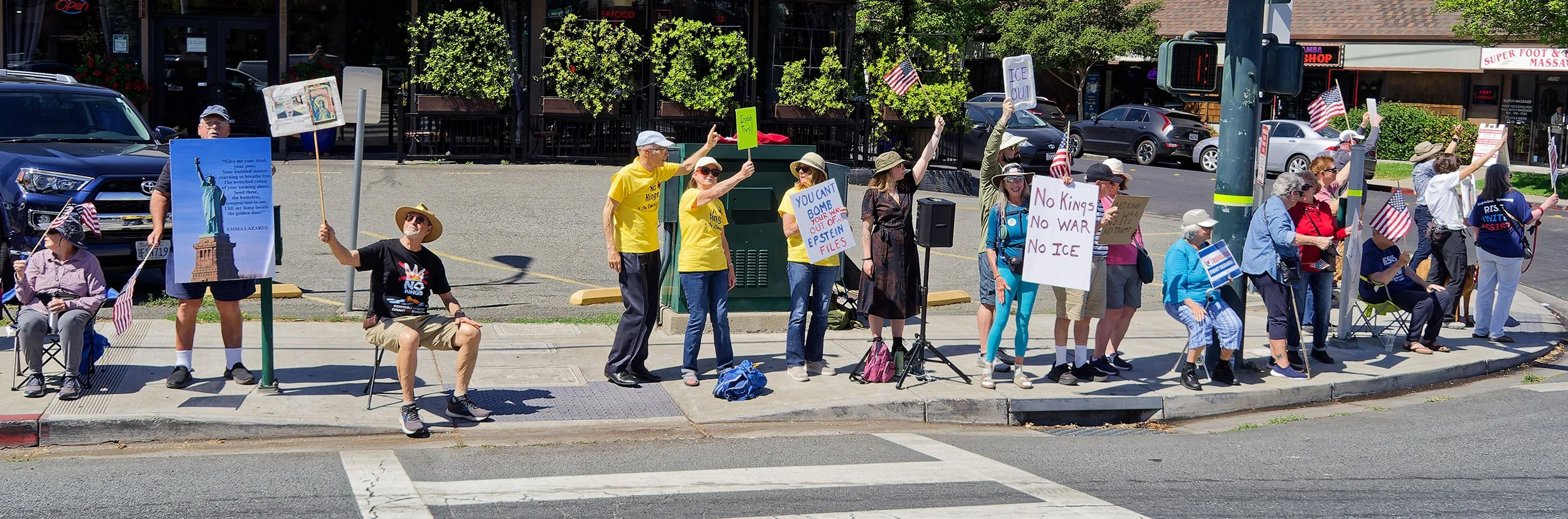 Demonstrators on the sidewalk, holding protest signs.