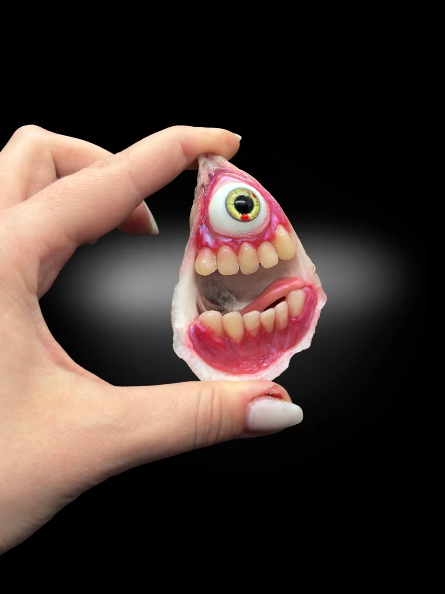 surreal oyster shell sculpture with teeth and glass eye monster inside
