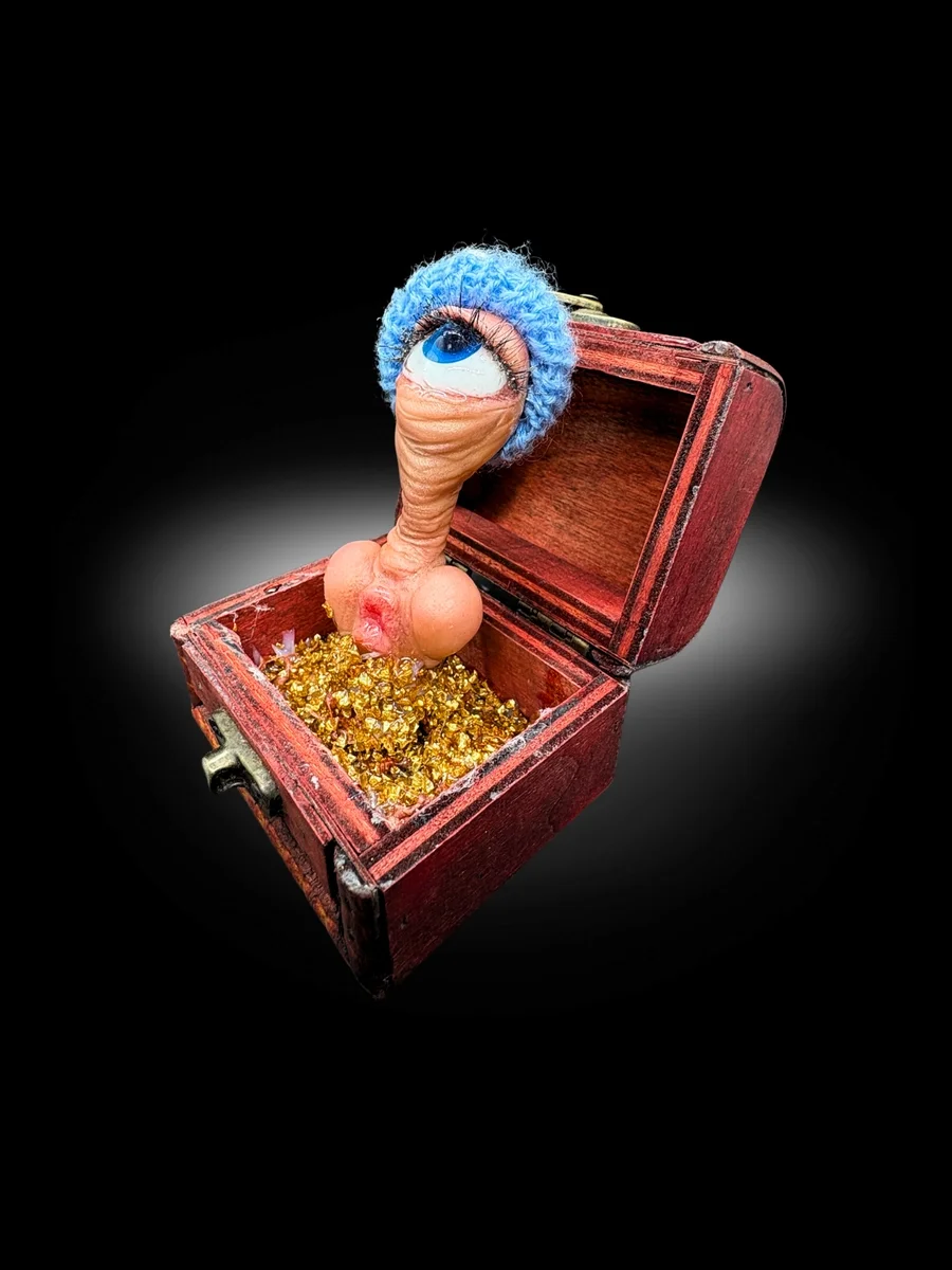 handmade conceptual art piece with single eye creature rising from gold box