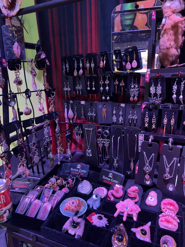 Rotten Cuties pieces at Connect: chainmail earrings and necklaces above pink clay lips, tongues and one-eyed creatures