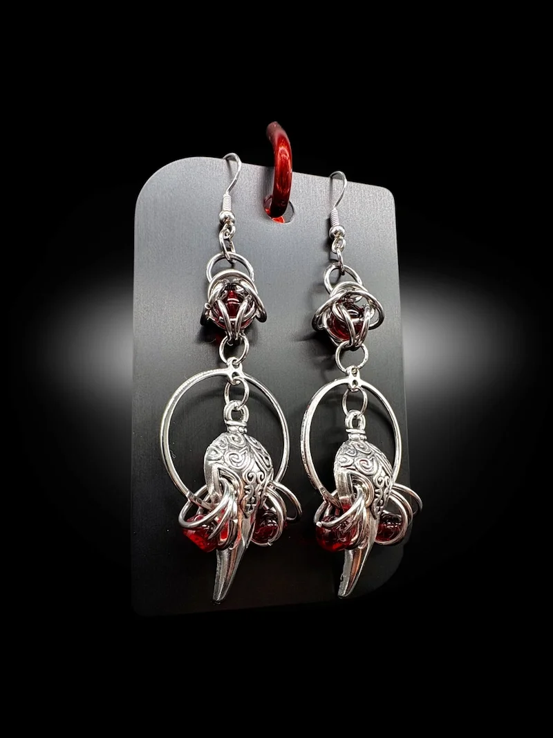 Birds Are Not Real gothic chainmail earrings on black display card