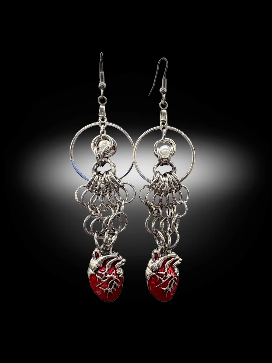Heavy Heart chainmail earrings with red anatomical hearts and pearl bead held in hand